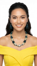 Load image into Gallery viewer, Woman wearing a yellow off-shoulder top and a long necklace with Sasha L Jewels green and blue stones 
