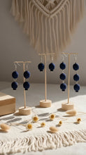 Load image into Gallery viewer, Sasha L Jewels Navy blue earrings on wooden stands with a macrame wall hanging in the background.