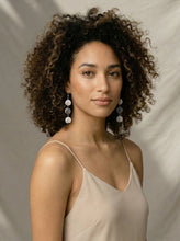 Load image into Gallery viewer, Woman with curly hair wearing a beige dress and Sasha L Jewels Black White Stripe Earrings for Summer