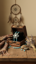 Load image into Gallery viewer, Wooden jewelry box with a Sasha L Jewels  flower-shaped pendant and turquoise beads, dreamcatcher in the background.
