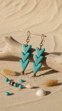 Load image into Gallery viewer, Sasha L Jewels Turquoise arrow-shaped earrings triple with brown beads on a sandy background