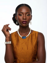 Load image into Gallery viewer, Woman wearing a mustard yellow dress with Sasha L Jewels white stone necklace with blue pendant and bracelet 